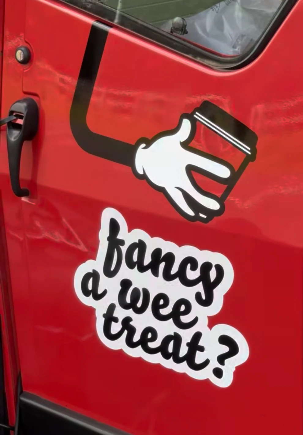 Annie's red door with the white-gloved hand logo and a fancy a wee treat sticker
